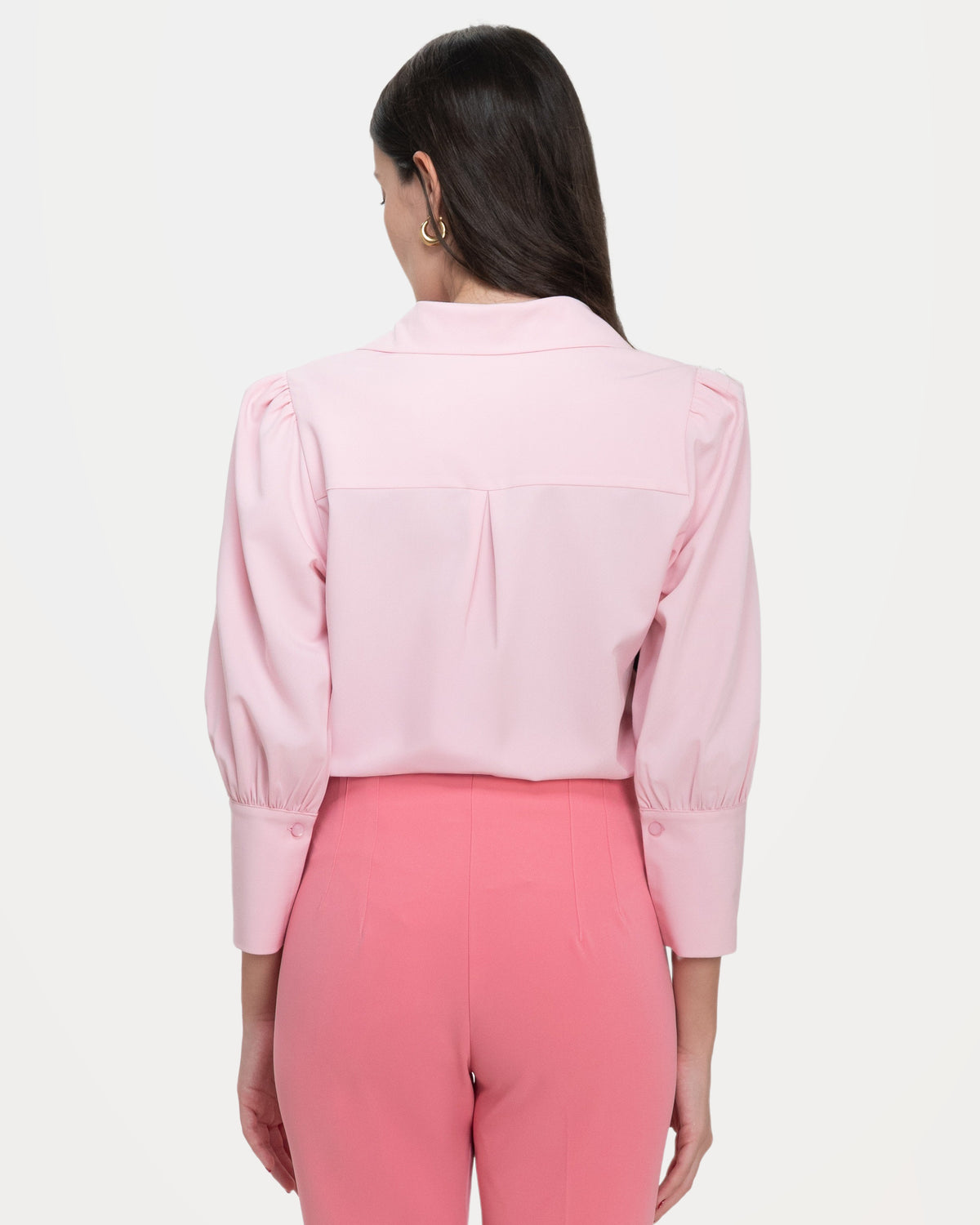 The back of the pale pink blouse: a shoulder yoke opening into a single centre pleat.